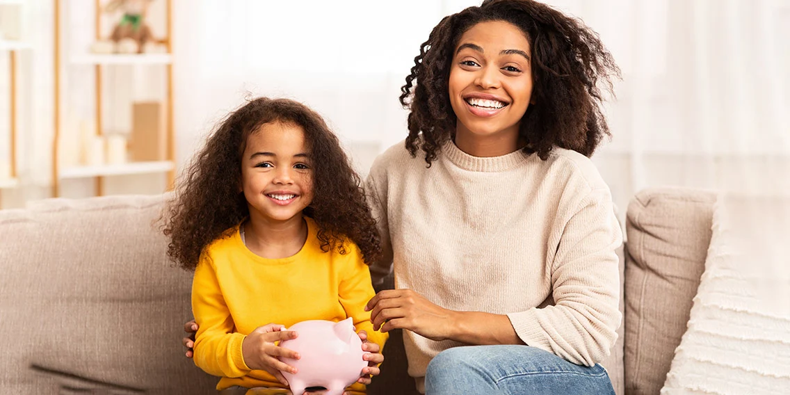 Child and mother with a piggy bank